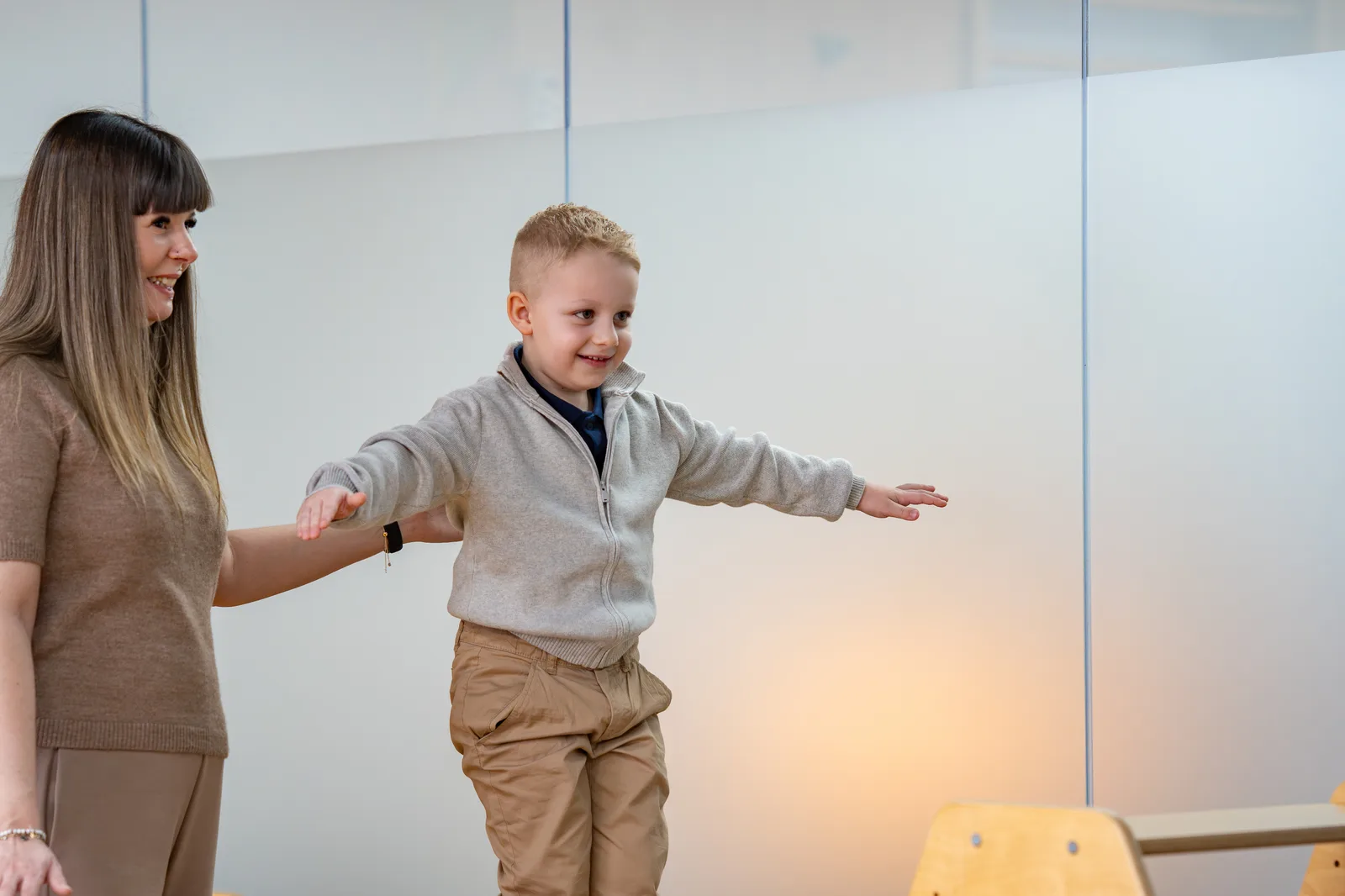 Therapeutin begleitet ein Kind bei einer Balance-Übung